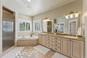 Bathroom with a stall shower, a bath, and double vanity