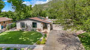 View of front facade with concrete driveway, brick siding, a gate, a chimney, and a garage