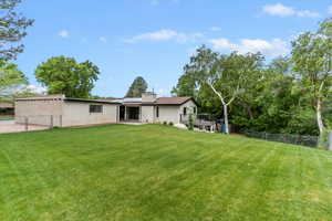 Back of house with a chimney, brick siding, a deck, and solar panels
