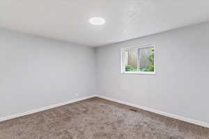 Spare room featuring baseboards and carpet floors