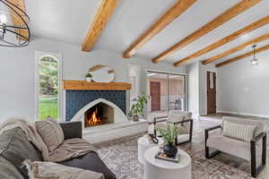 Living room with wood laminate finished floors, a warm lit fireplace, and baseboards