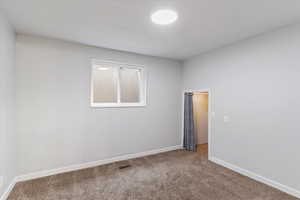 Unfurnished room featuring carpet and baseboards