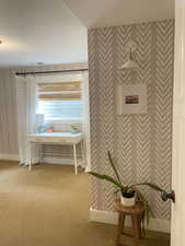 Bathroom featuring wallpapered walls and baseboards