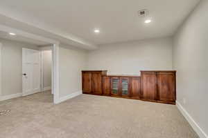 Below grade area with light colored carpet, baseboards, and recessed lighting