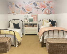 Carpeted bedroom featuring a wainscoted wall
