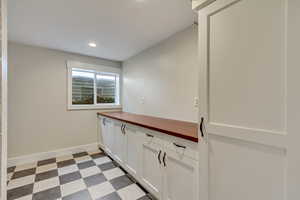 Washroom featuring recessed lighting, light floors, and baseboards