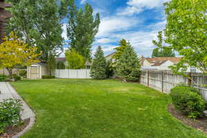 View of yard featuring a shed, an outdoor structure, and a residential view