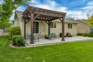 Rear view of house featuring a pergola, a patio area, and roof with shingles