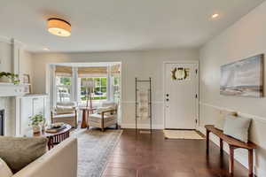 Foyer with dark wood-style flooring, recessed lighting, and baseboards