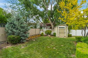 View of yard with a storage shed and an outbuilding