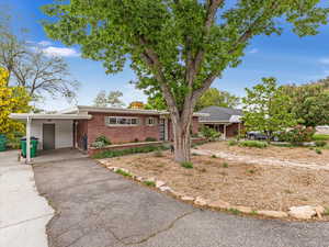 Ranch-style house with brick siding, asphalt driveway, and an attached carport