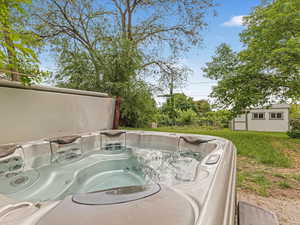 View of pool featuring an outbuilding and a hot tub