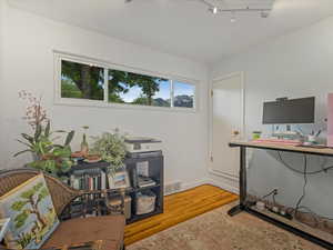 Office area with light wood-type flooring, baseboards, and track lighting