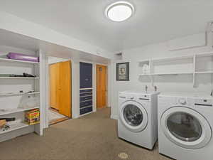 Washroom with separate washer and dryer and carpet flooring