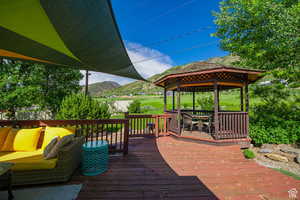 Wooden terrace featuring a gazebo and a mountain view