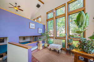Sunroom / solarium with lofted ceiling and a baseboard heating unit