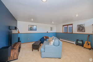 Living area with a baseboard radiator, carpet floors, and recessed lighting