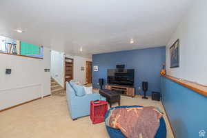Carpeted living room with stairway, recessed lighting, and baseboards