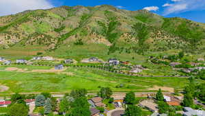 Aerial view of property and surrounding area featuring a mountain backdrop