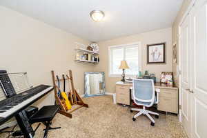 Office area featuring light carpet, a textured ceiling, and baseboards