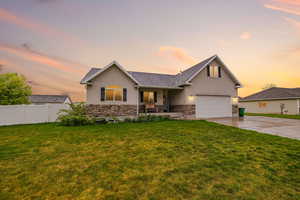 View of front of house with stucco siding, a porch, concrete driveway, and stone siding