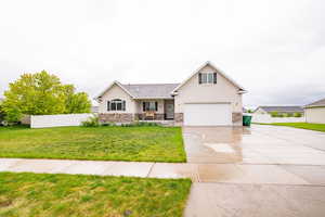 View of front of home featuring driveway, stucco siding, stone siding, and a garage