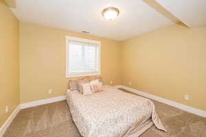 Carpeted bedroom featuring a textured ceiling and baseboards