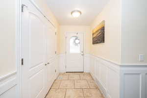 Entryway featuring a wainscoted wall and a decorative wall