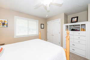Bedroom with a closet, carpet floors, and ceiling fan