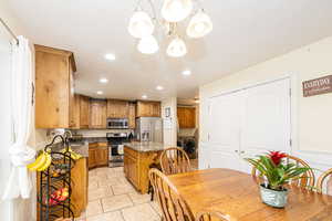 Kitchen with appliances with stainless steel finishes, independent washer and dryer, a chandelier, recessed lighting, and a kitchen island