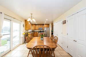 Dining area with light tile patterned floors, plenty of natural light, a chandelier, and recessed lighting