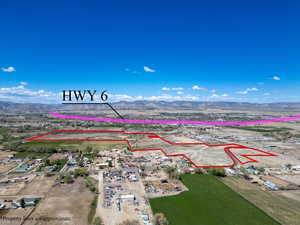 Aerial view of property and surrounding area featuring a mountainous background and property parcel outlined