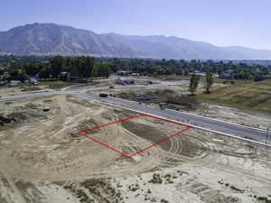 Aerial view of property's location with property parcel outlined and a mountainous background