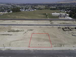 Aerial view of property and surrounding area featuring property parcel outlined and a mountainous background