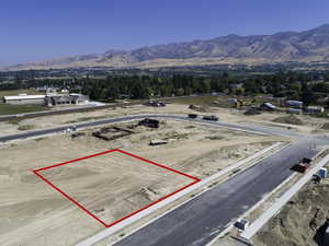 Aerial view of property's location with property parcel outlined and a mountainous background