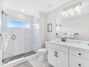 Full bath featuring toilet, a stall shower, vanity, a chandelier, and tile patterned flooring