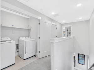 Clothes washing area featuring washer and dryer, recessed lighting, and light tile patterned flooring