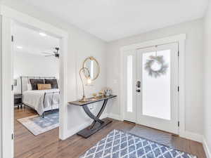 Foyer with wood finished floors, baseboards, and ceiling fan