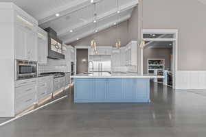 Kitchen featuring beamed ceiling, hanging light fixtures, dark wood-style floors, white cabinets, and decorative backsplash