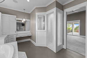 Bathroom featuring ornamental molding, a shower stall, a garden tub, dark tile patterned flooring, and a ceiling fan
