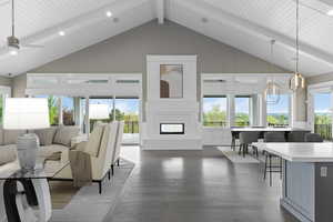 Living room featuring high vaulted ceiling, dark wood-style floors, a fireplace, plenty of natural light, and a decorative wall