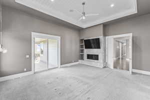 Unfurnished living room with ceiling fan, carpet flooring, baseboards, a high end fireplace, and recessed lighting