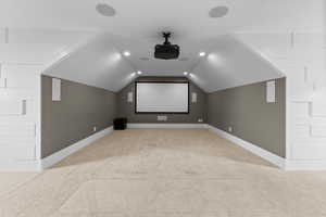 Home theater with light carpet, lofted ceiling, baseboards, and recessed lighting