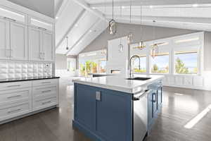 Kitchen featuring a wainscoted wall, white cabinetry, dark wood-style flooring, hanging light fixtures, and a decorative wall