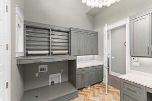Laundry room featuring cabinet space, electric dryer hookup, washer hookup, and baseboards