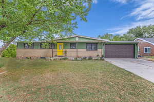 Ranch-style house with brick siding, covered porch, an attached garage, concrete driveway, and a front yard