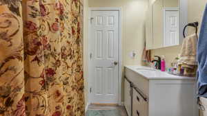 Full bathroom with vanity and curtained shower