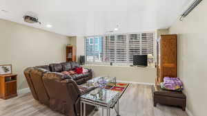 Living room with light wood-type flooring, recessed lighting, and baseboards