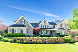 View of front of home with stone siding, a front yard, a mountain view, and a chimney