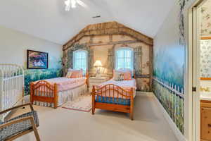Bedroom with lofted ceiling, carpet, ensuite bathroom, a ceiling fan, and wallpapered walls